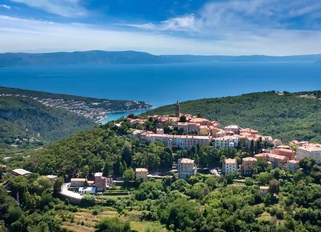 Planinski krajolik i naselje uz more.