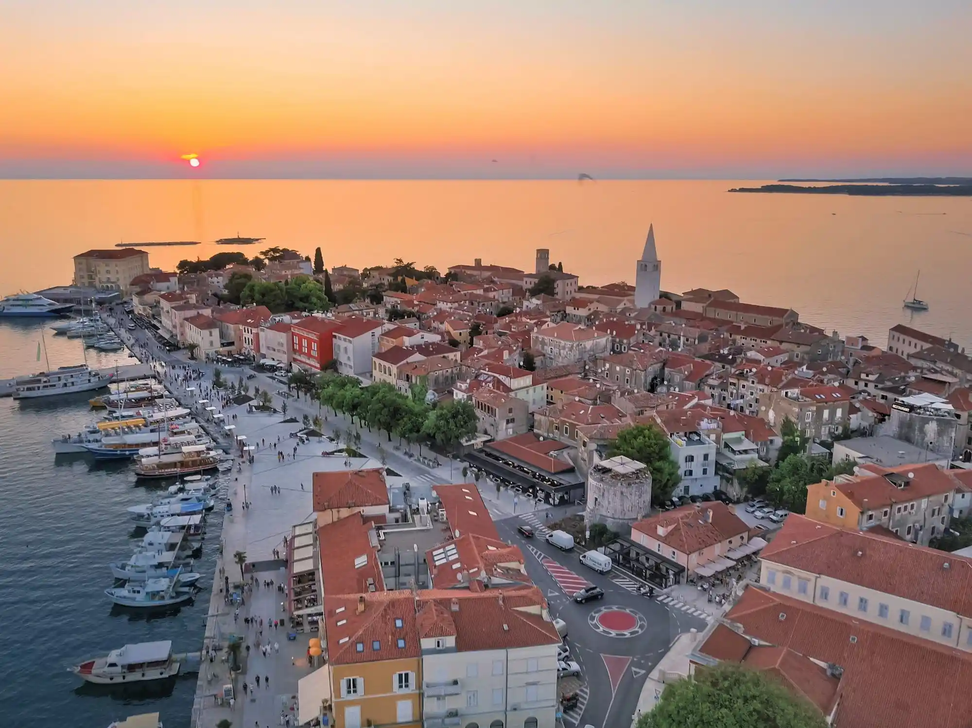 Pogled na zalazak sunca iznad grada uz more.