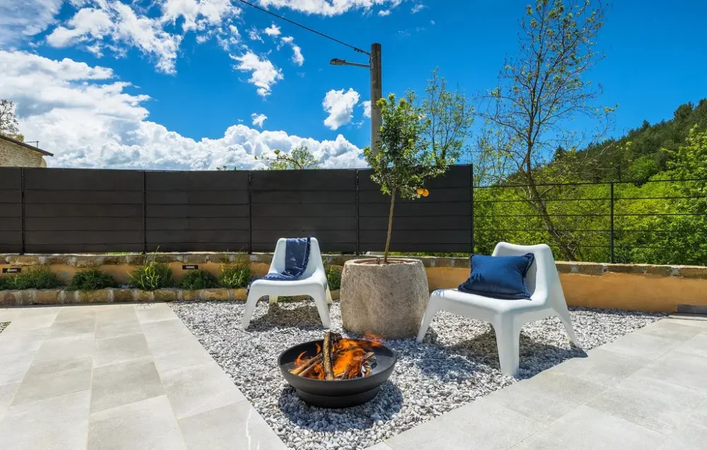 Outdoor relaxing area with chairs and fire pit.