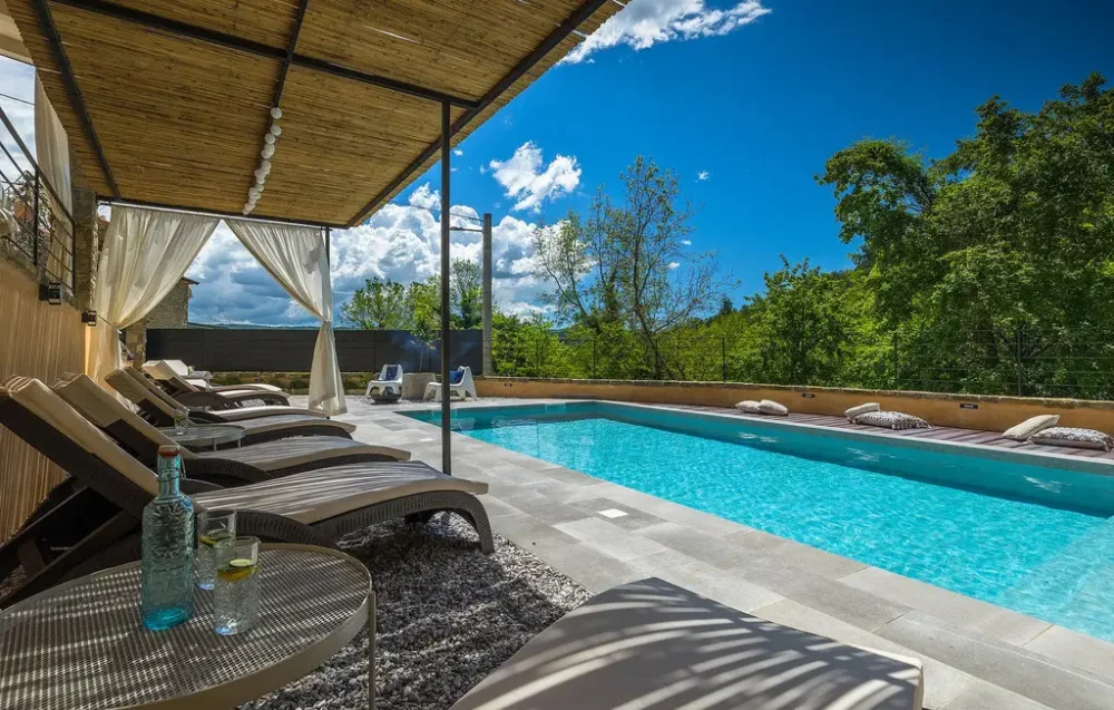 Outdoor pool with lounge chairs and canopy shade.