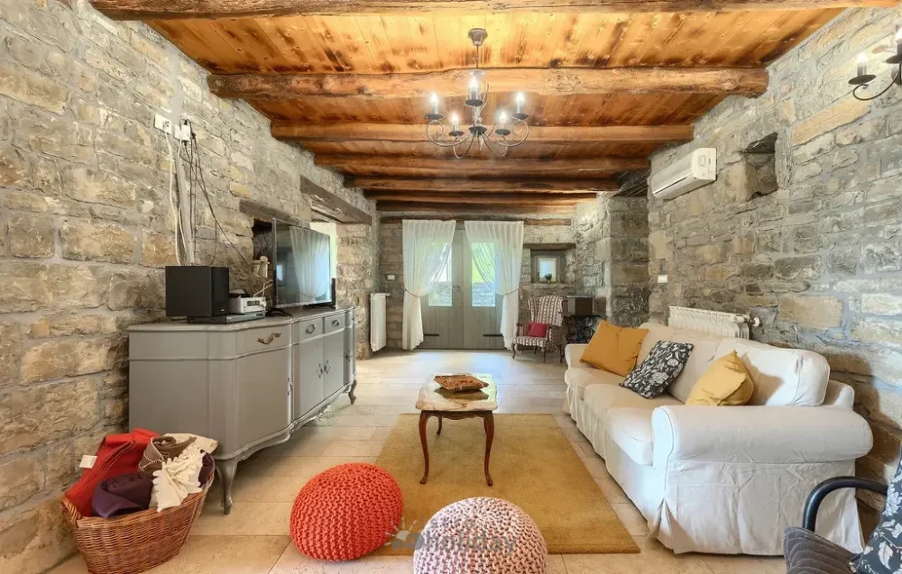 Cozy rustic living room with stone walls.