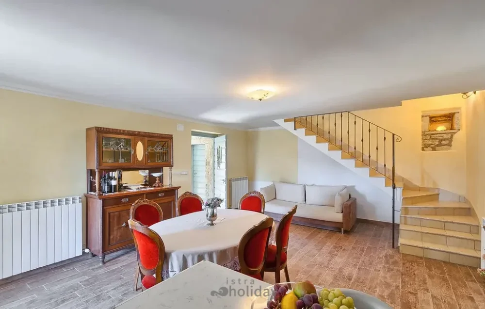 Cozy dining room with staircase and sofa.