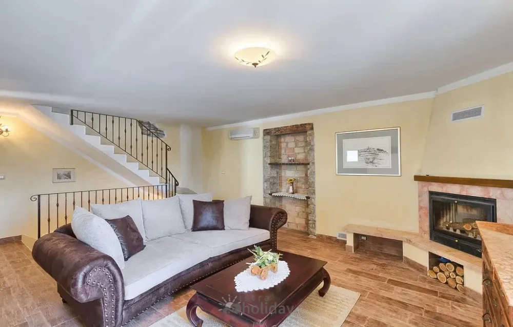 Cozy living room with sofa and fireplace.