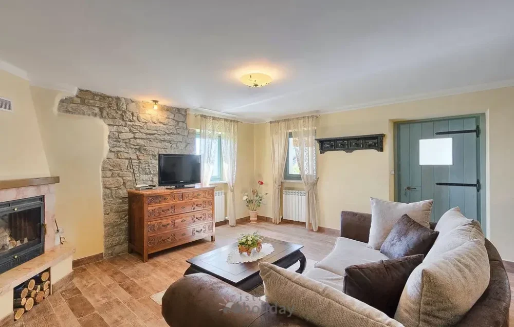 Cozy living room with stone wall and fireplace.