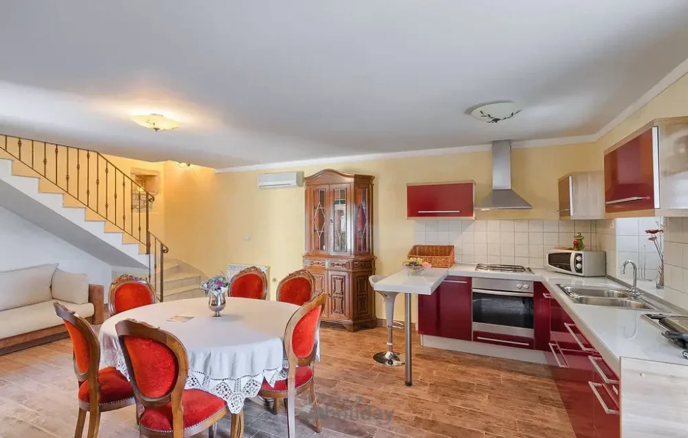 Spacious modern kitchen dining area with staircase.