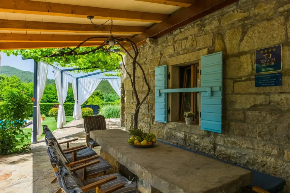 Rustic patio with stone table and chairs.