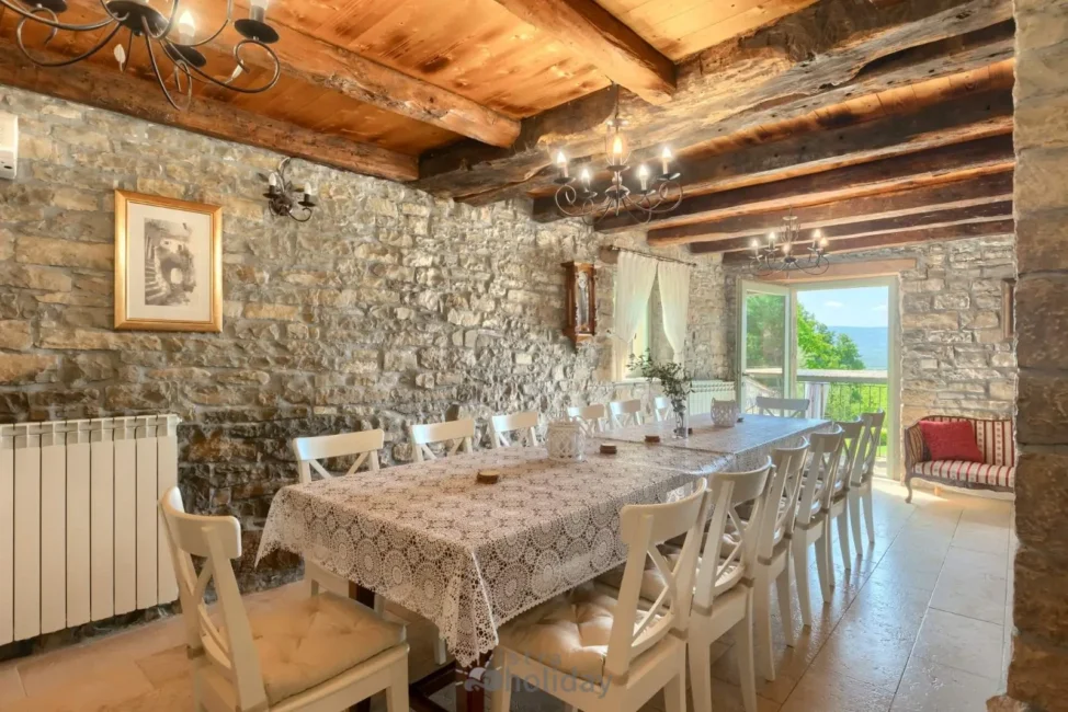 Rustic dining room with stone walls and large table.