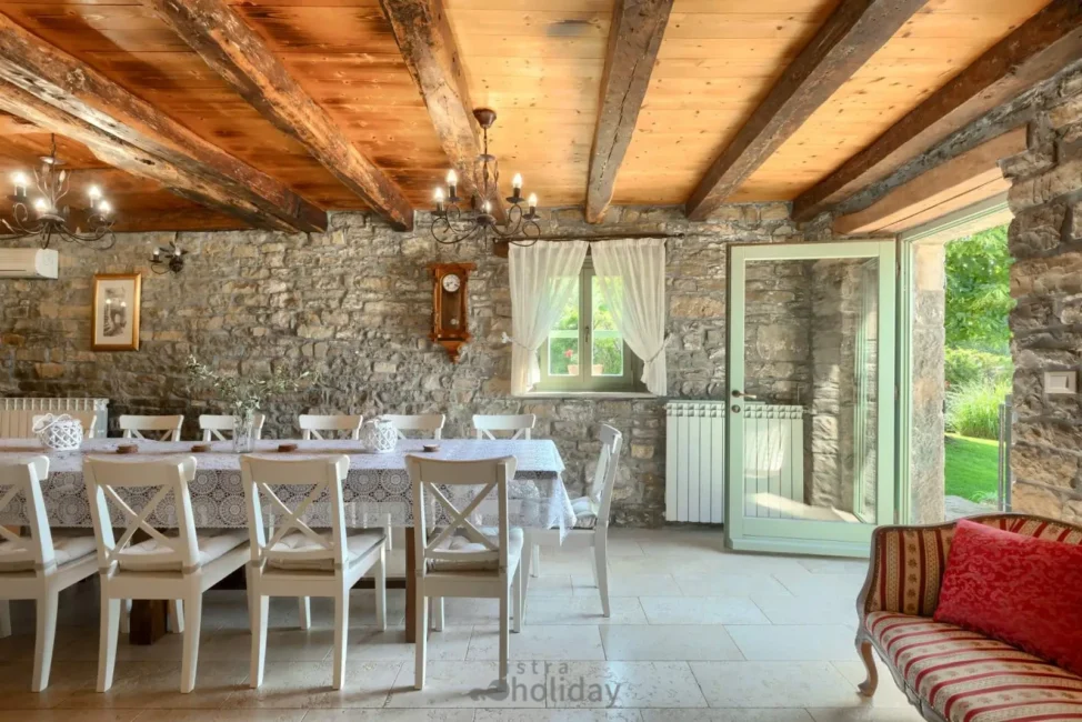 Rustic dining room with large table and stone walls.