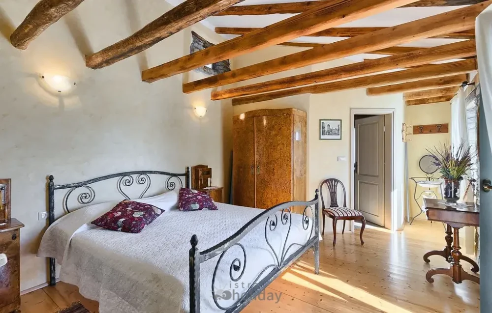 Rustic bedroom with wooden beams and metal bed