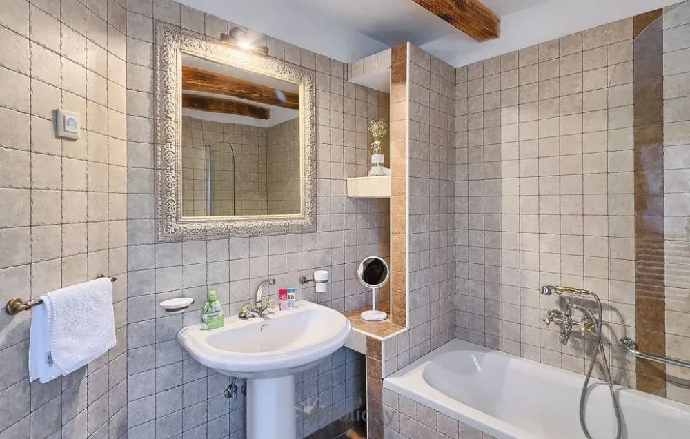 Elegant bathroom with tiled walls and mirror.