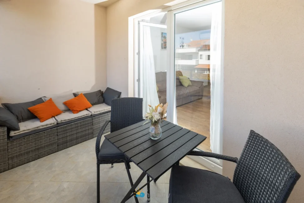 Cozy balcony with table, chairs, and cushioned bench