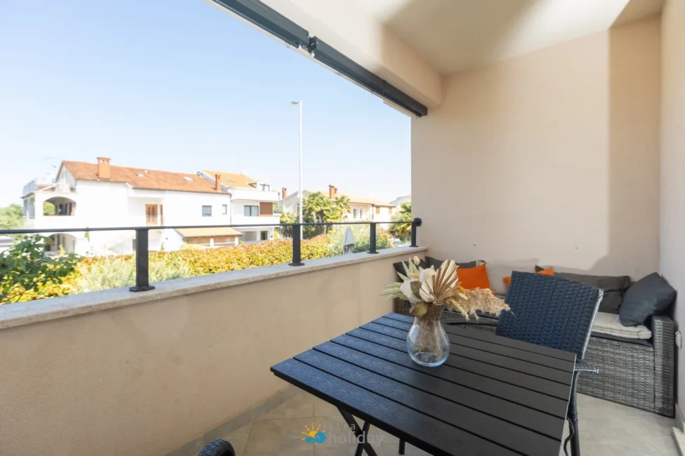 Covered balcony with table and neighborhood view