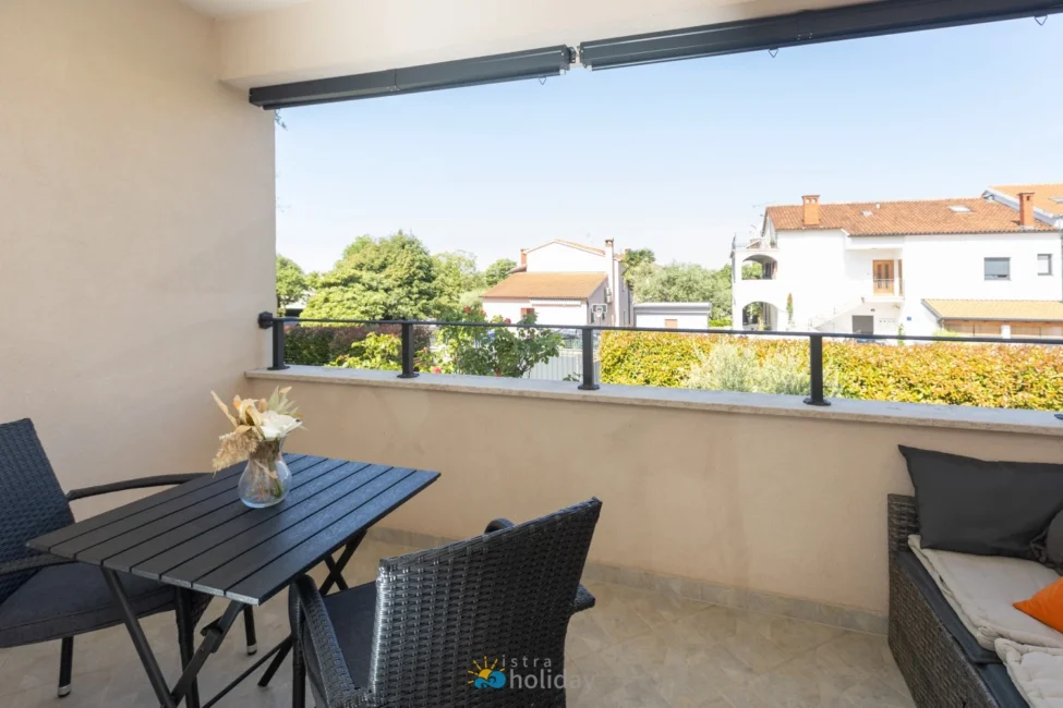 Sunny balcony with table overlooking neighborhood homes