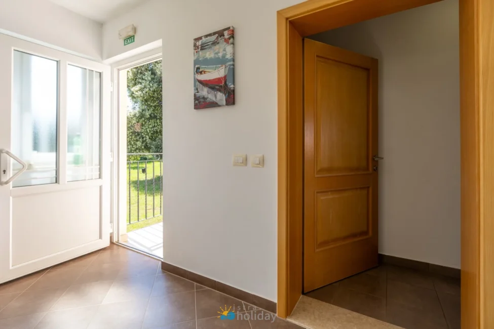 Sunlit entryway with open door and balcony view