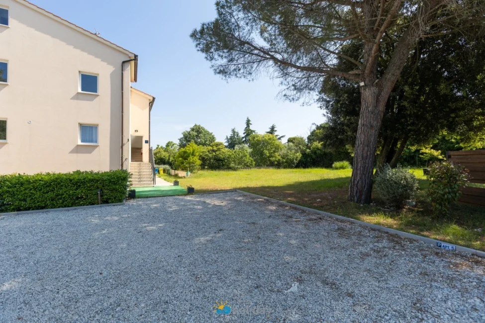 Residential building with gravel driveway and green lawn