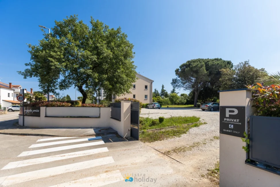 Private guest parking entrance with gravel lot