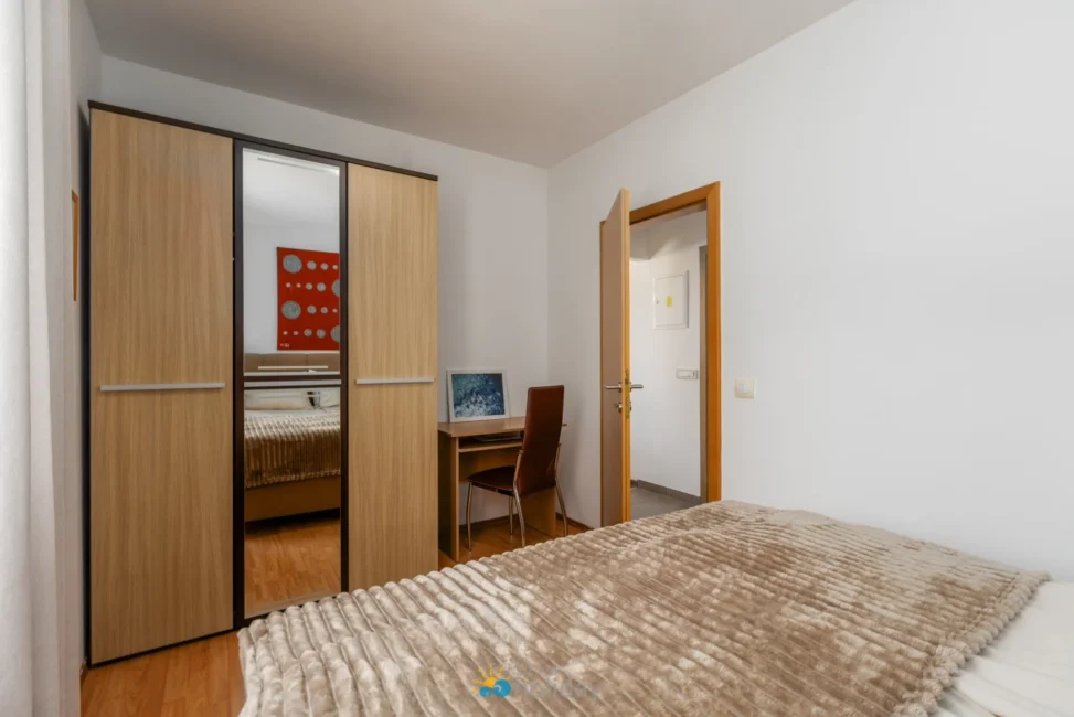 Modern bedroom with mirrored wardrobe and desk