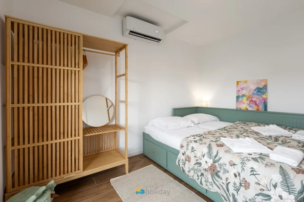 Modern bedroom with green bed and wooden wardrobe