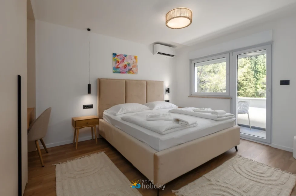 Modern bedroom with beige bed and balcony view