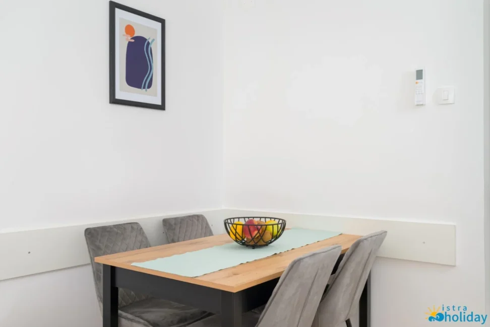 Modern dining area with artwork and fruit bowl