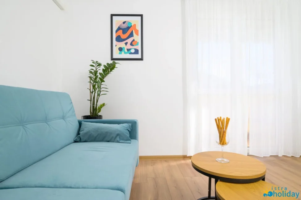 Minimalist living room with blue sofa and decor.