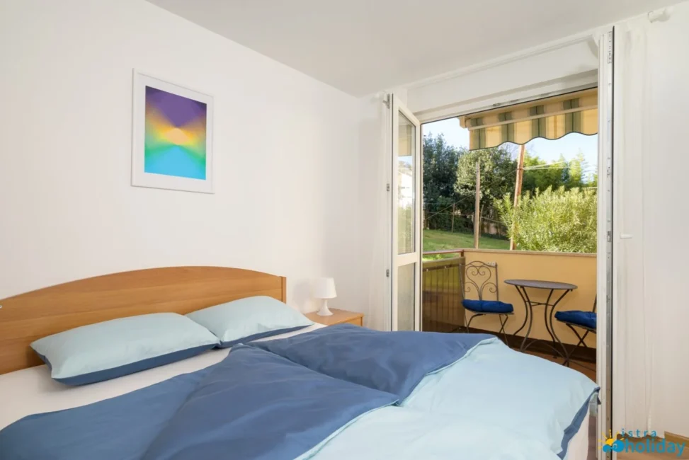 Bedroom with balcony view and vibrant artwork.