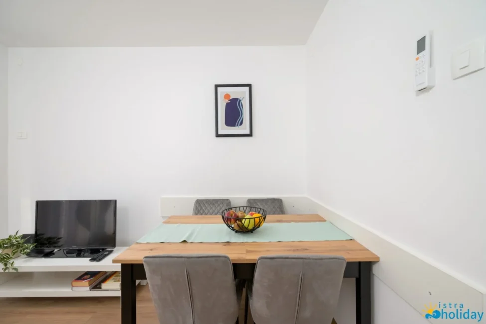 Cozy dining area with wall art and TV.
