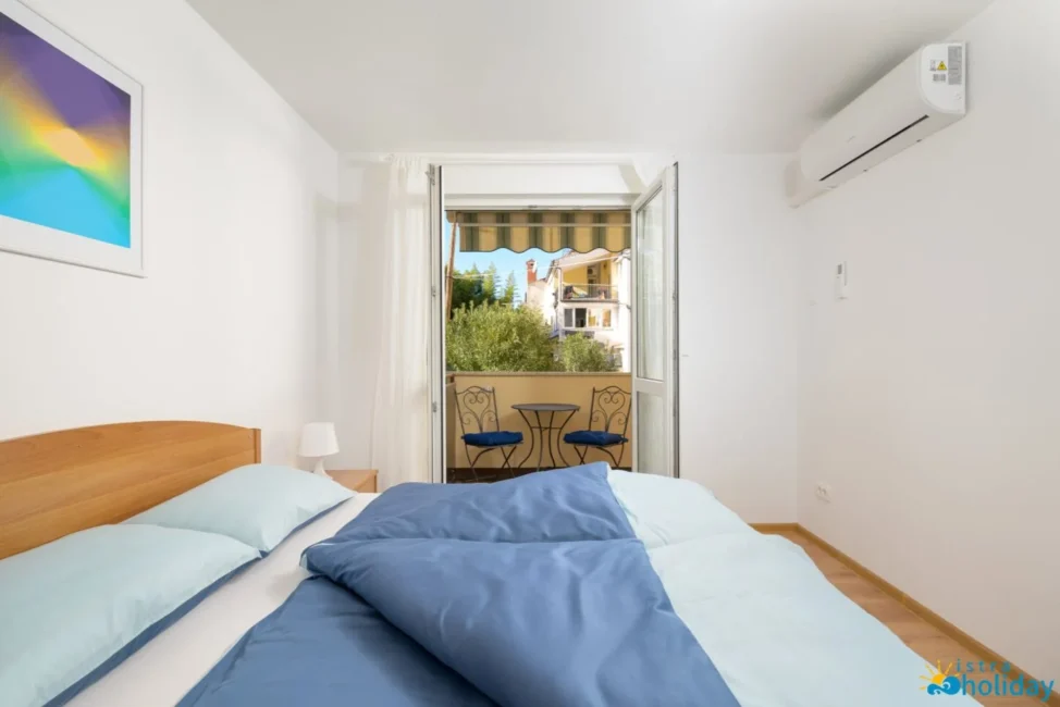 Bedroom with balcony view and blue bedding.