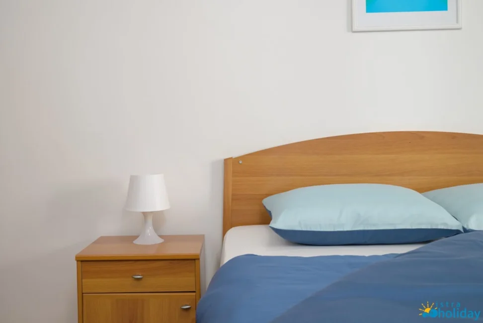 Cozy bedroom with blue bedding and lamp
