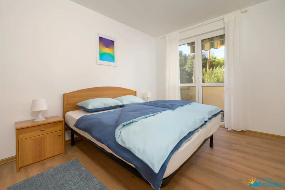 Comfortable bedroom with double bed and window view.