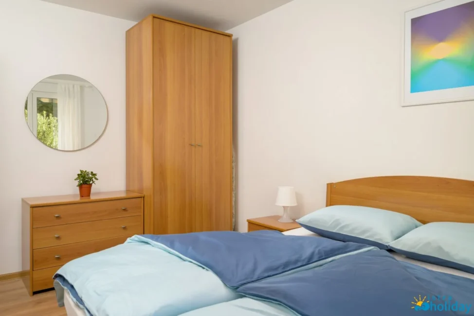 Cozy bedroom with wooden furniture and blue bedding.