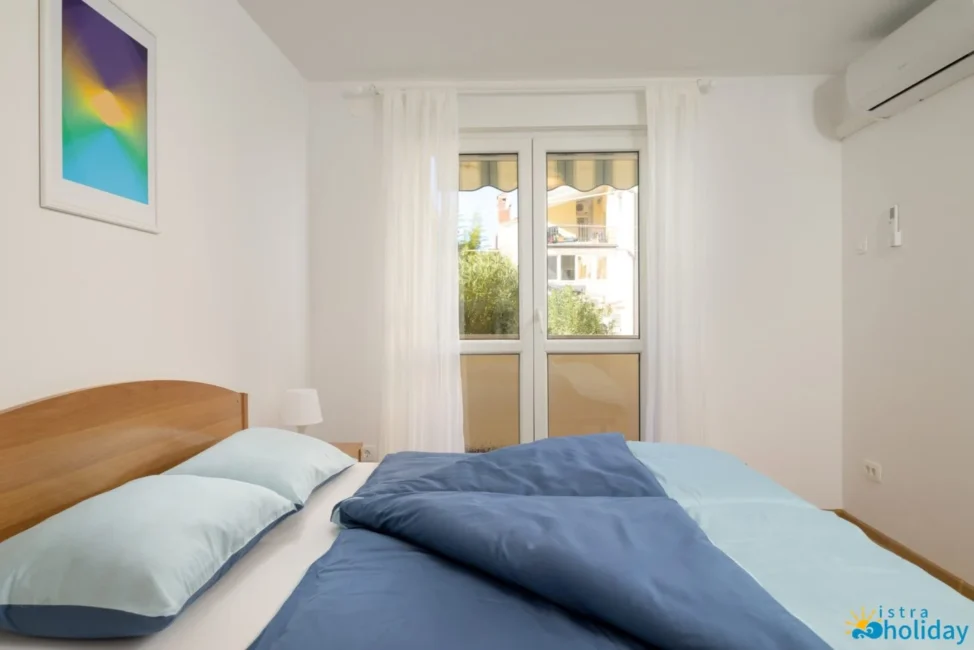 Bright bedroom with window, modern decor, cozy ambiance.