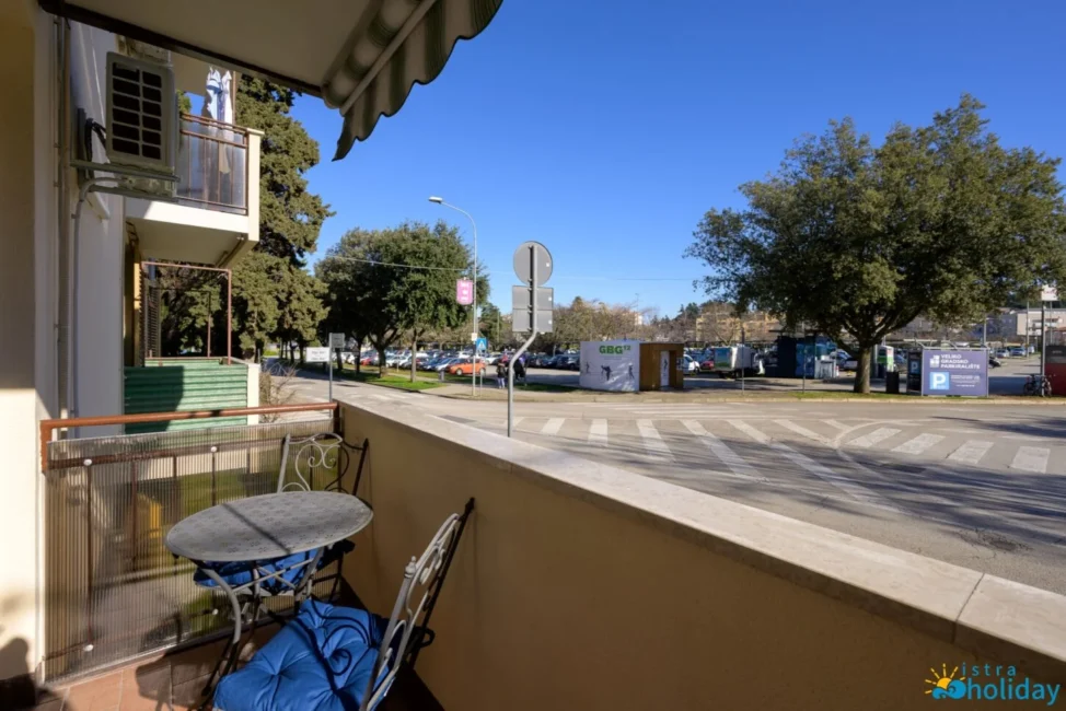 Sunny balcony with street view and table.