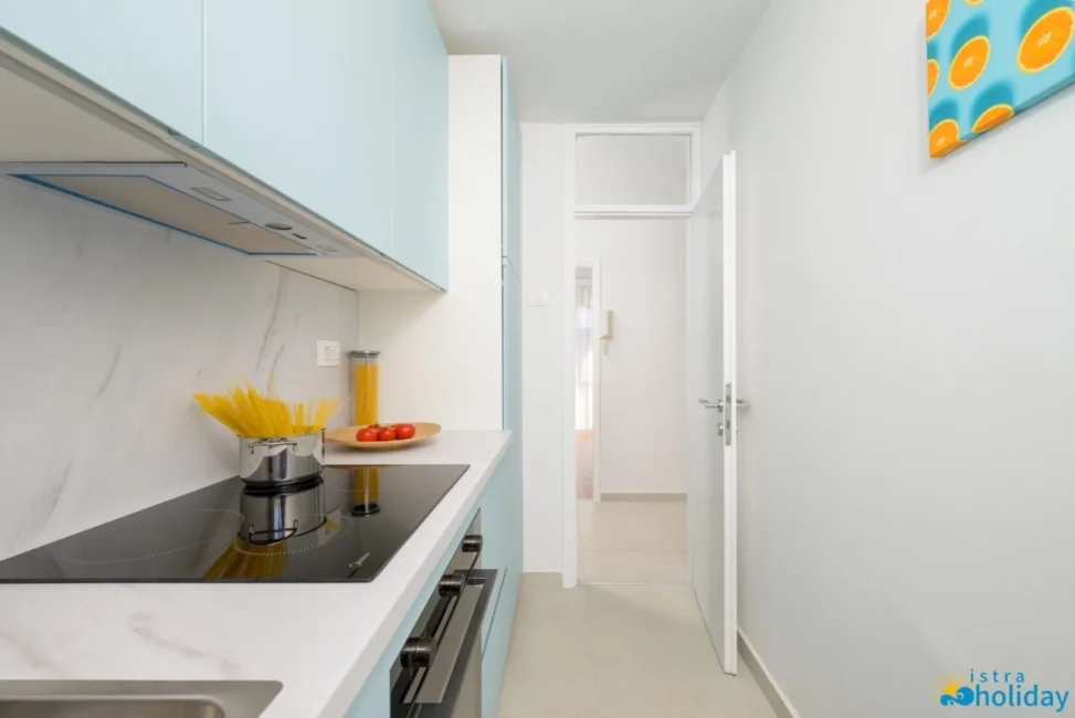 Modern kitchen with stovetop and pasta jar.