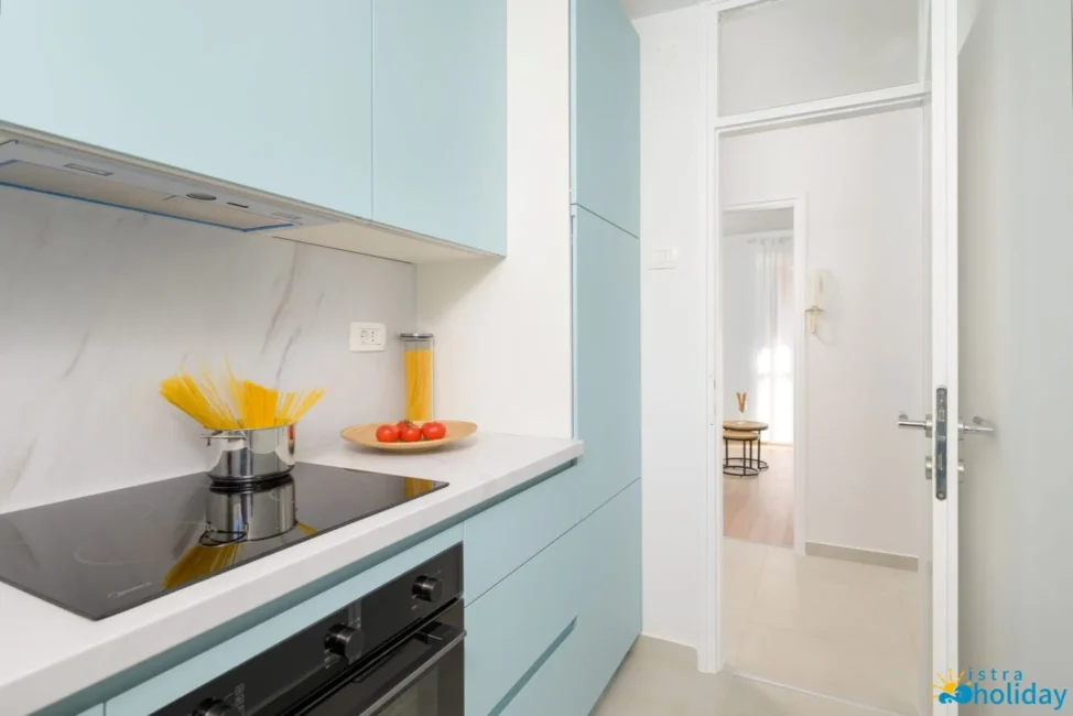 Modern kitchen with induction stove and blue cabinets.