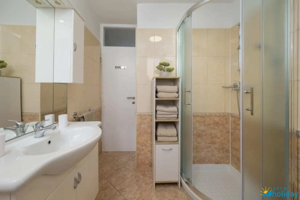 Modern bathroom with towels and glass shower.