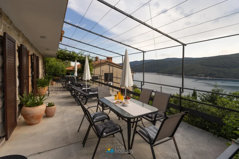 Lakeside terrace with dining table and lounge chairs