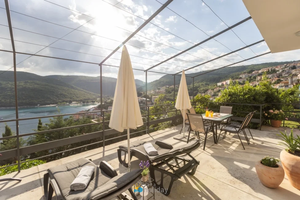 Sunny terrace overlooking coastal bay and hills