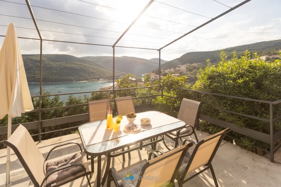 Terrace dining table overlooking scenic coastal bay