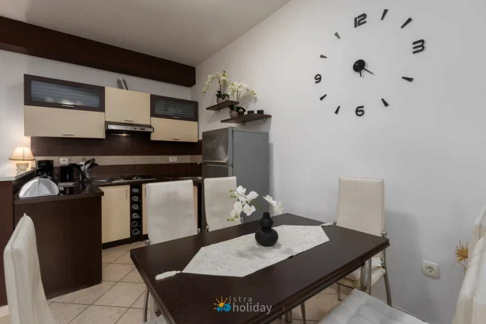 Modern kitchen and dining area with wall clock