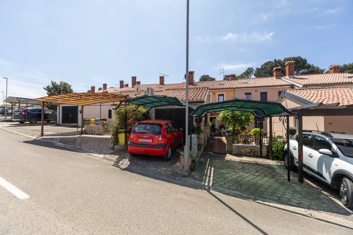 Row of townhouses with carports and parked cars