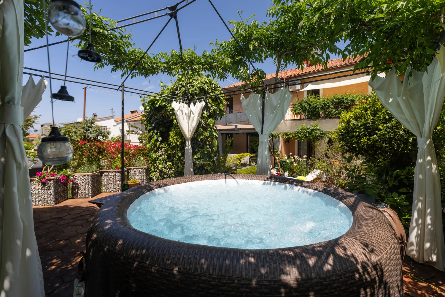 Outdoor inflatable hot tub under garden pergola