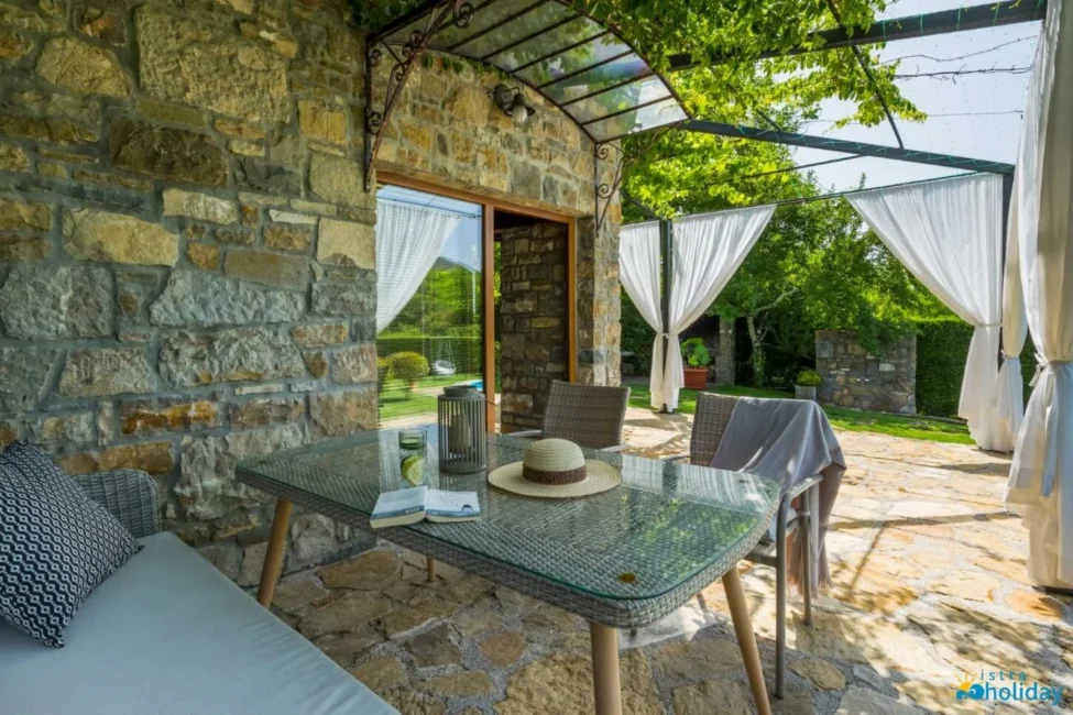 Cozy patio with table, chairs, and greenery.