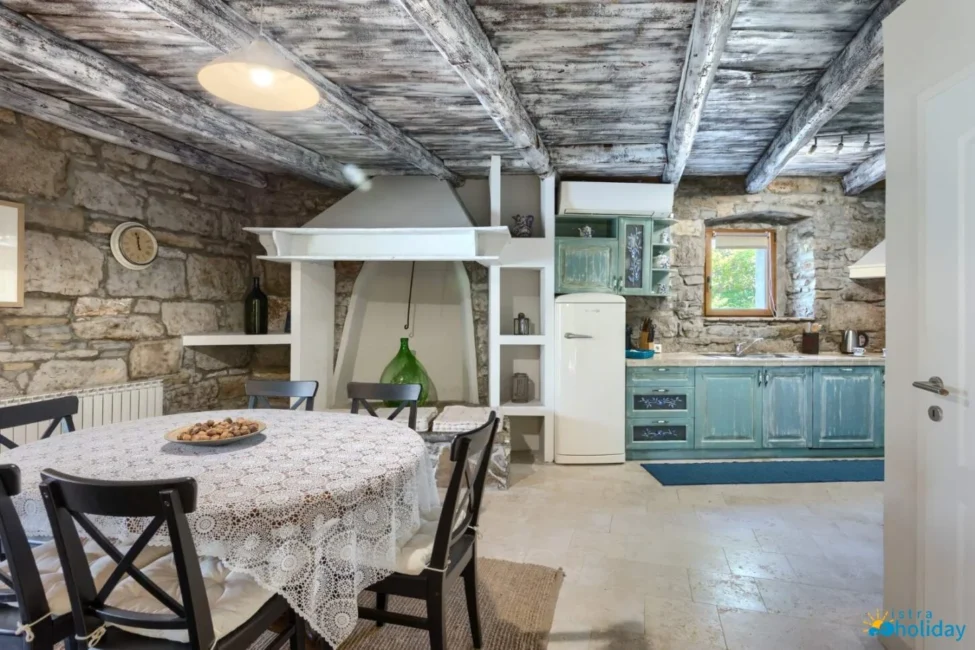 Rustic kitchen with stone walls and vintage decor.