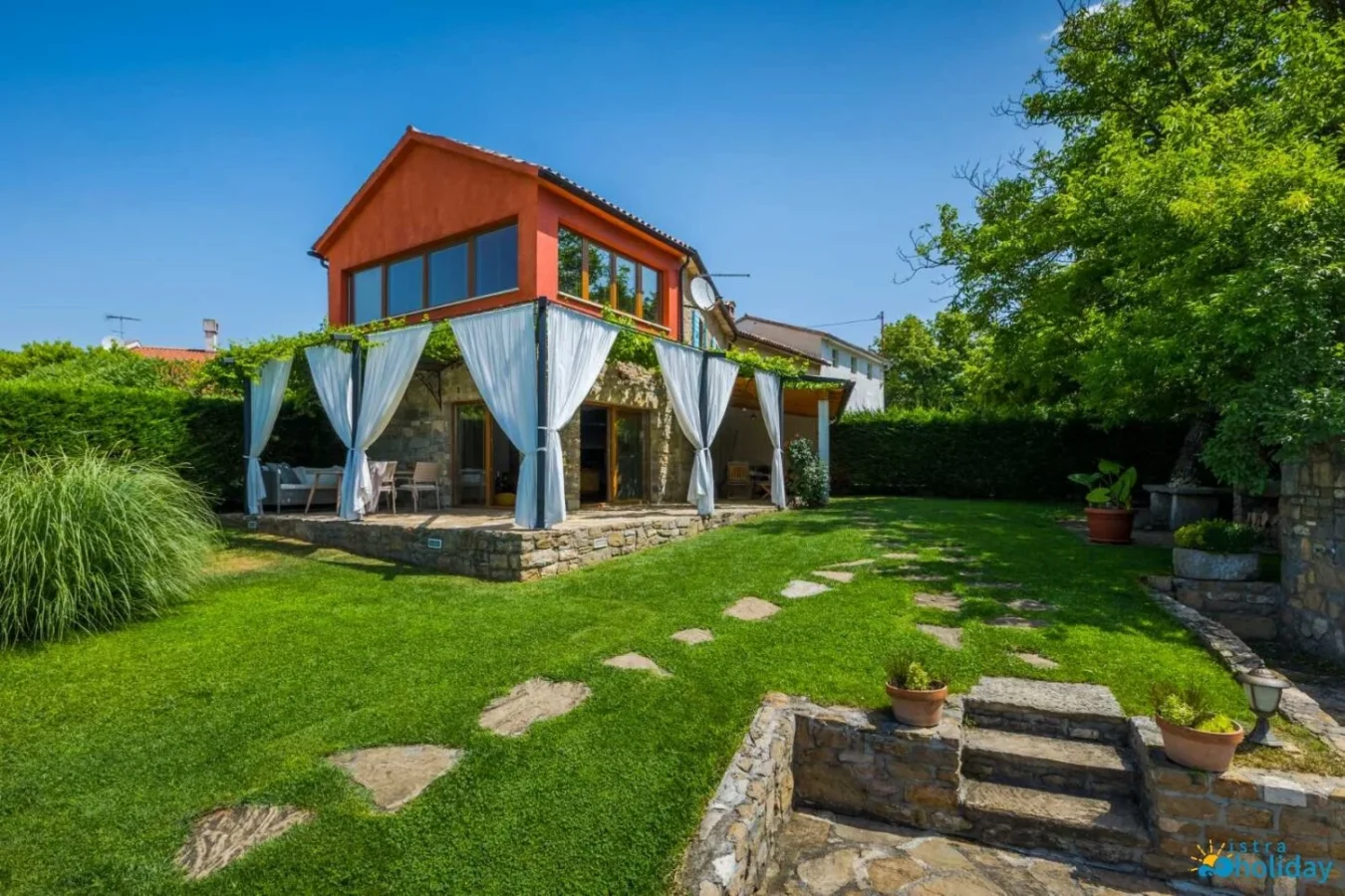 Charming house with curtains in landscaped garden
