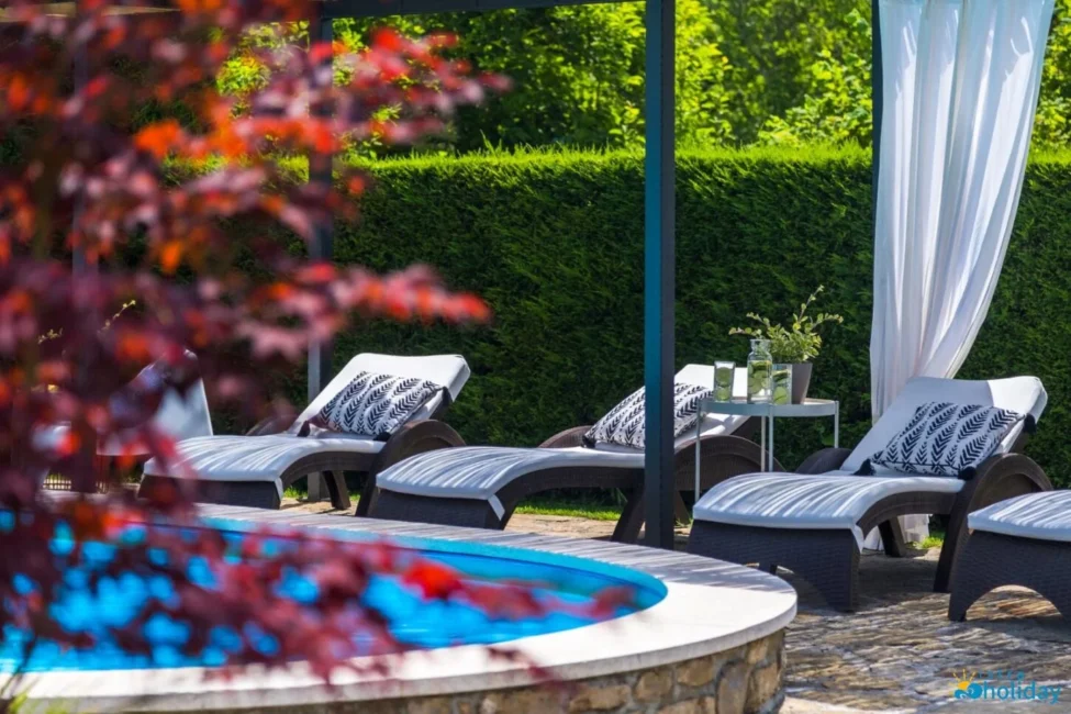 Poolside lounge chairs with decorative pillows.