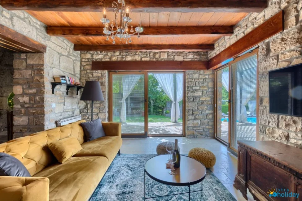 Rustic living room with stone walls and wooden beams.