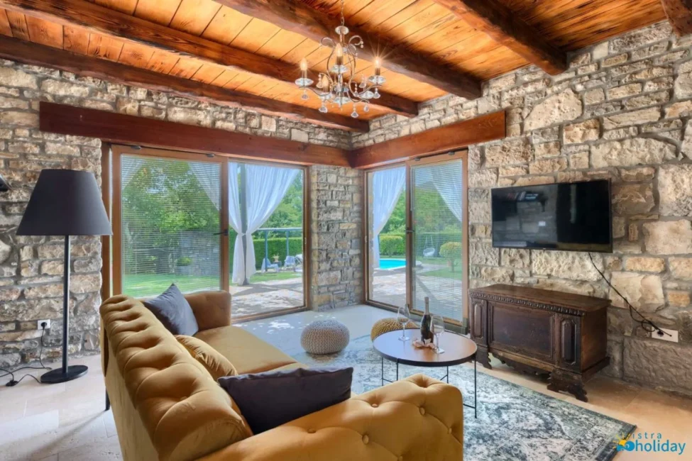 Rustic living room with stone walls and garden view.
