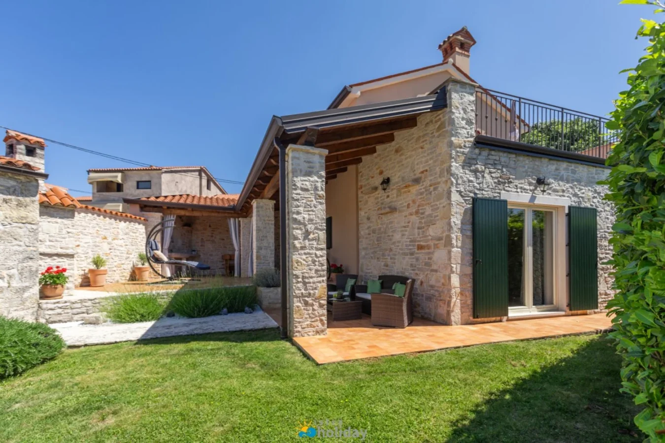 Stone house with patio and green shutters