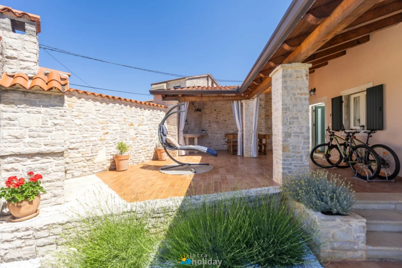 Stone courtyard patio with hanging chair and bicycles